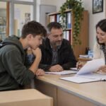 Srednjoškolac i otac proveravaju dokumentaciju za učeničku stipendiju u školi