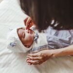 Majka nežno pomaže bebi sa zapušenim nosom