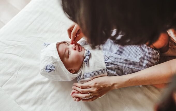 Majka nežno pomaže bebi sa zapušenim nosom