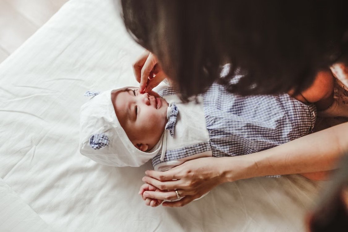 Majka nežno pomaže bebi sa zapušenim nosom