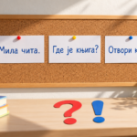 Tri kartice sa ćiriličnim rečenicama na plutanoj tabli, uz upitnik i uzvičnik na stolu.